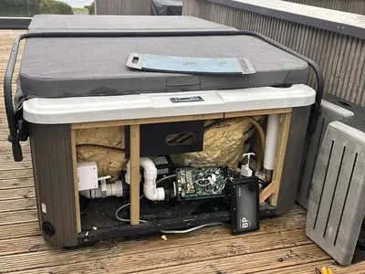 Hot tub control pack and pipework exposed during a repair