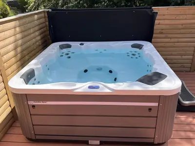 Clean hot tub with clear water on a timber deck