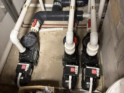 Pool circulation pumps and pipework in a plant room